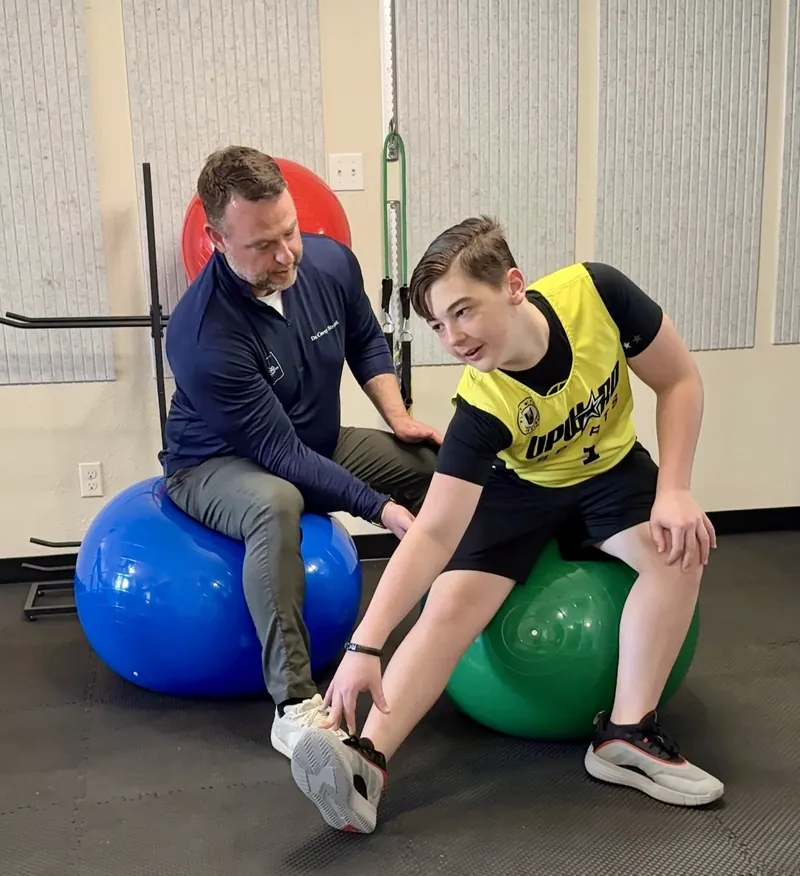 Dr. Corey working on posture correction with a young athlete