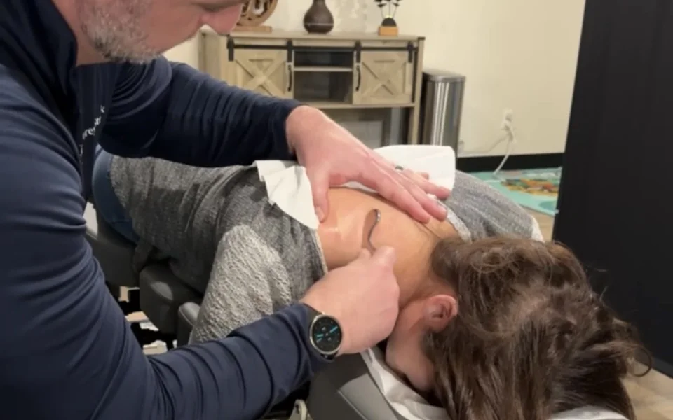 Dr. Corey performing a wellness consultation and neck adjustment